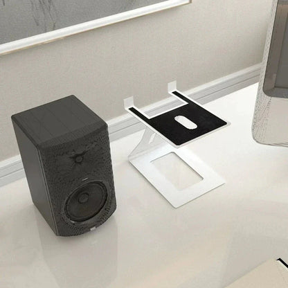 Black textured desktop speaker with circular driver and control knob on professional bookshelf speaker stand support