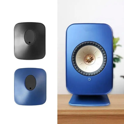 Blue kef speaker with circular grille and gold center next to black professional studio monitors on speaker stands professional for surround sound speaker setup