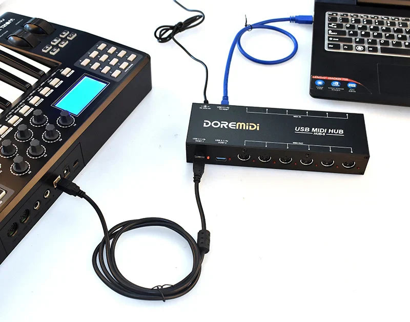 Black doremidi hub-8 6x6 midi interface host with multiple ports and a blue cable connected showing the back side