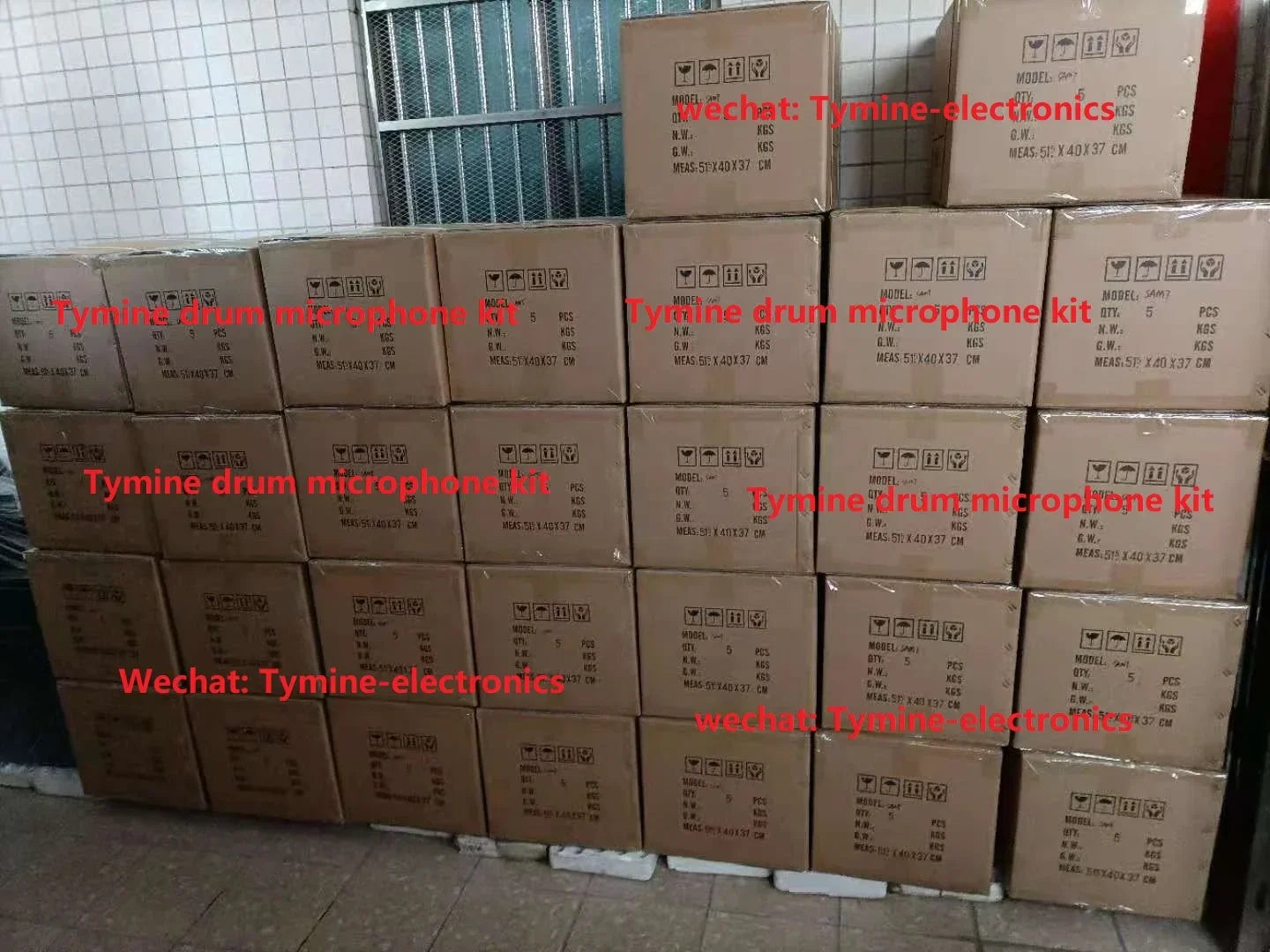 Stacks of brown cardboard boxes labeled tymine drum microphone kit and aluminum microphone kit for drum use