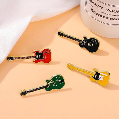 Four colorful enamel electric guitar brooches with metallic gold outline and black fretboard details for personalized use