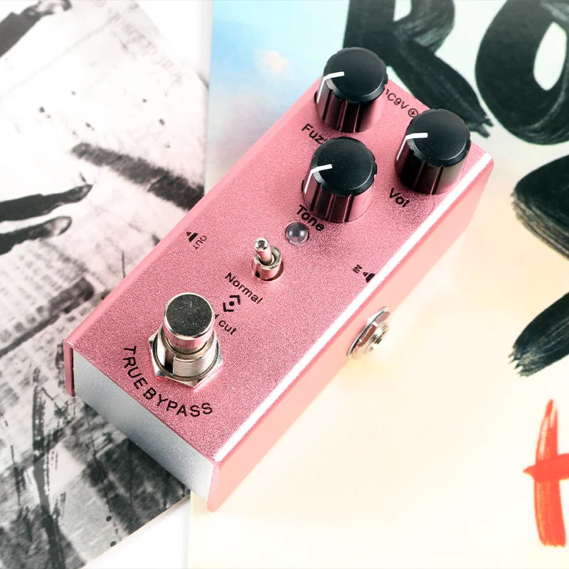 Pink metallic electric guitar effect pedal with control knobs overdrive and distortion tremolo delay features