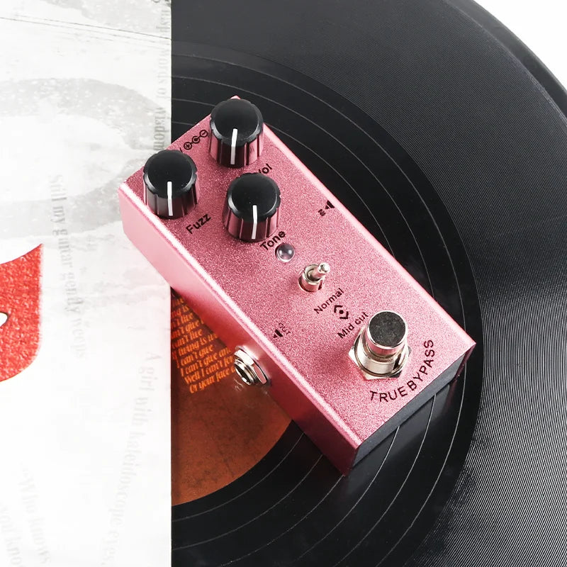Pink metallic electric guitar effect pedal with black control knobs overdrive distortion tremolo delay and silver footswitches