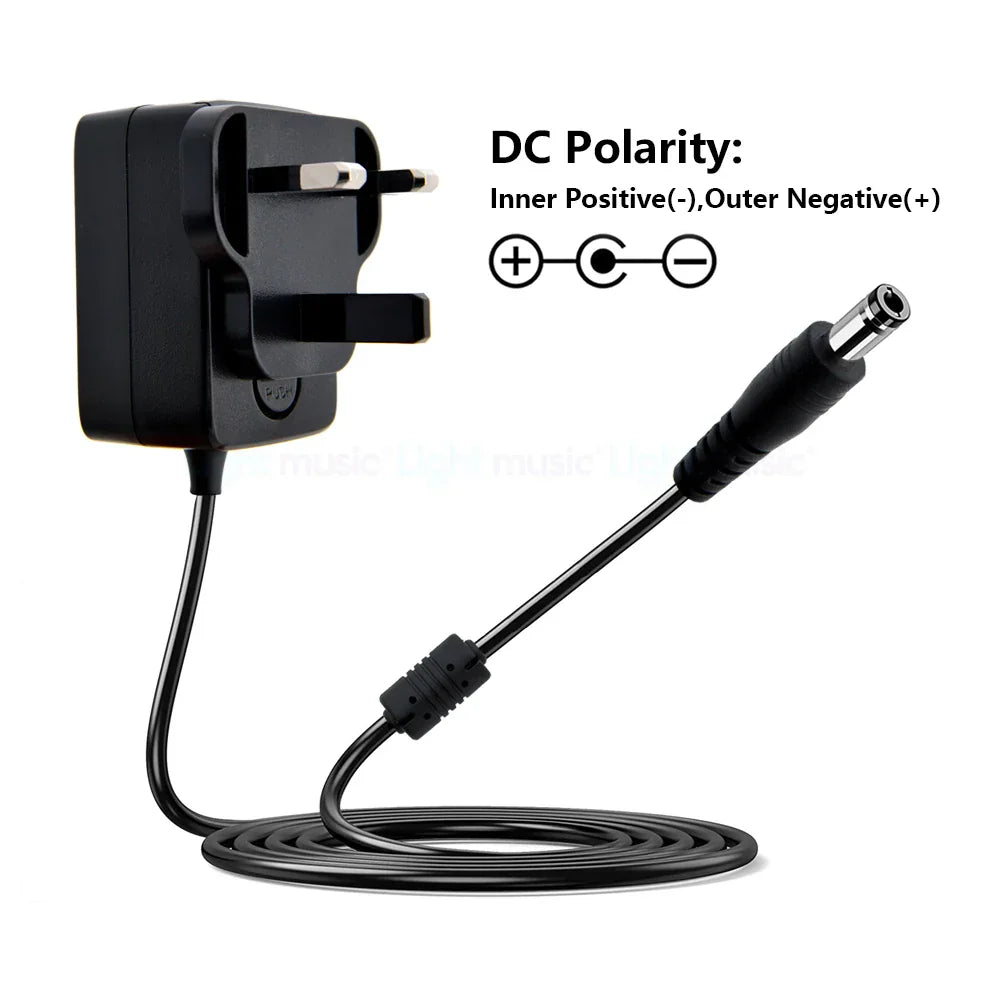 Black plastic electric guitar pedal power adapter with uk plug and coiled cable featuring true bypass design