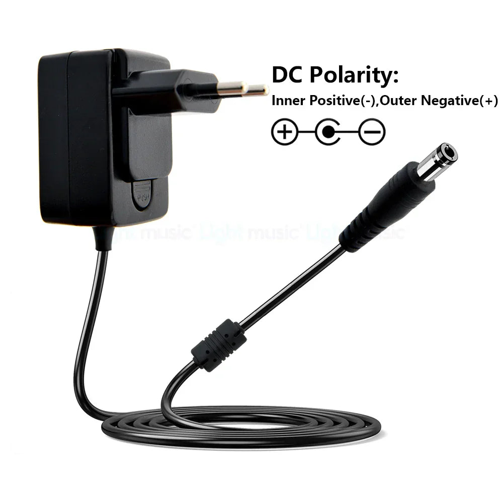 Black plastic electric guitar pedal adapter with coiled cable and dc connector for vintage overdrive and true bypass design