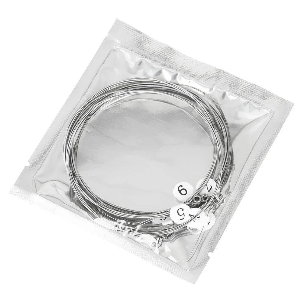 Silver electric guitar strings made of nickel alloy in clear plastic bag with white numbered labels for musical instruments accessories