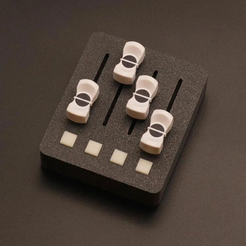 Set of four white plastic guitar tuning pegs with black accents on foam backing for em-po2 midi controller streaming control