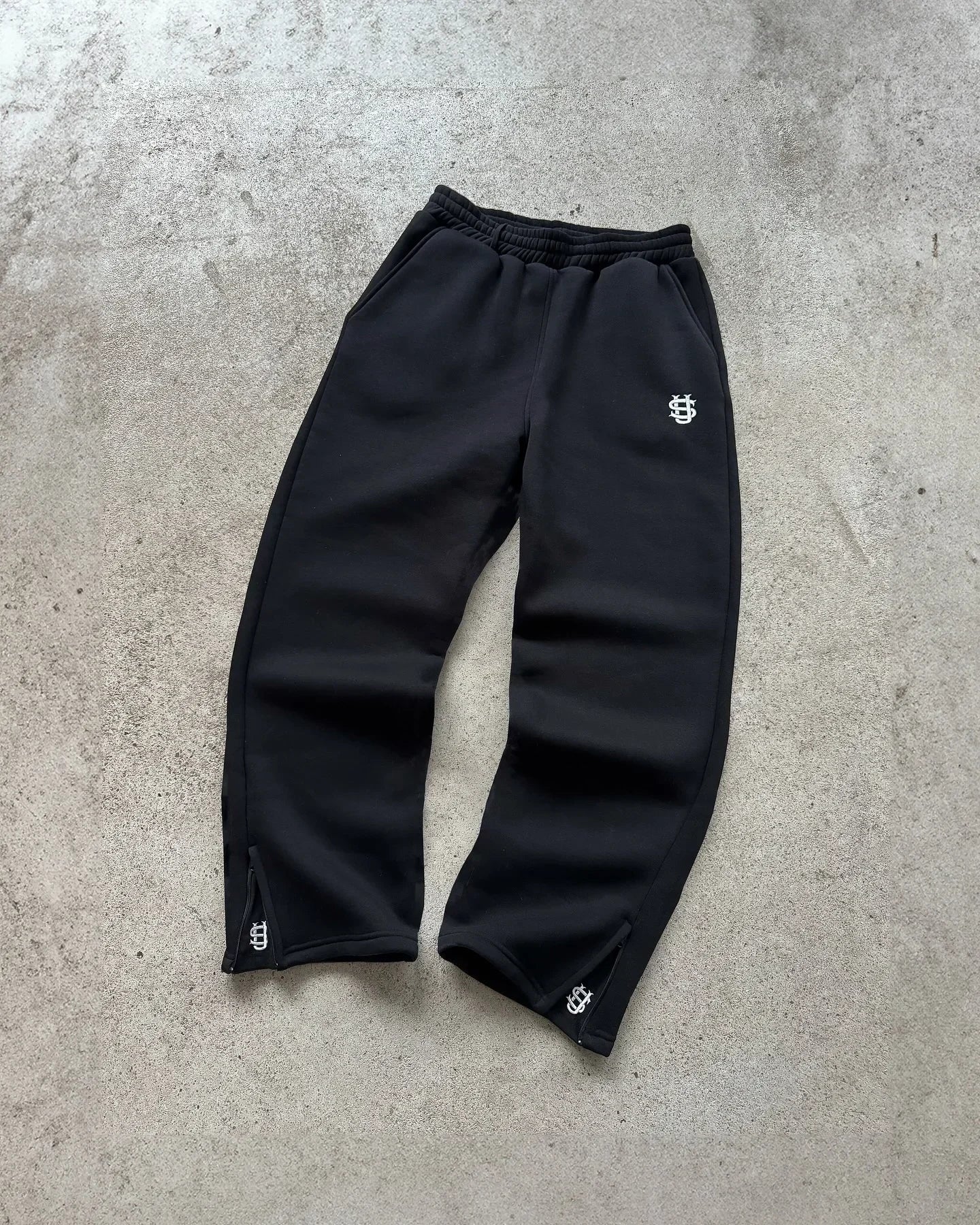 Black embroidered sweatpants with subtle white logo and matching cuffs in set y2k clothing oversized sweatpants casual style