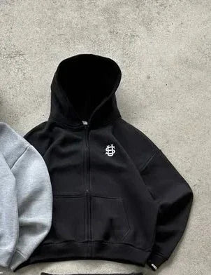 Black oversized zip-up hoodie with white embroidered logo on chest from embroidered sweatpants set y2k clothing line