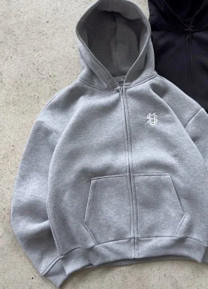 Gray zip-up hoodie with white embroidered logo on chest front pocket in oversized sweatpants casual set y2k clothing