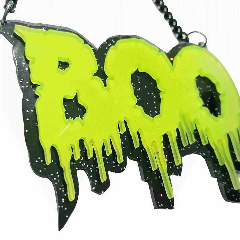 Vibrant neon green boo pendant with dripping design on black glittery base for black letter halloween necklace street trend