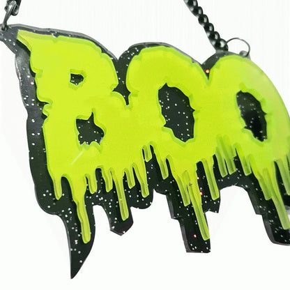 Vibrant neon green boo pendant with dripping design on black glittery base for black letter halloween necklace street trend