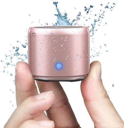A compact rose gold ewa a106pro mini bluetooth speaker with custom bass radiator, blue power indicator light, and ipx7 waterproof design
