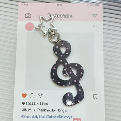 A black glittery fashion cartoon acrylic musical note keychain with pink polka dots and a silver star top kawaii charm