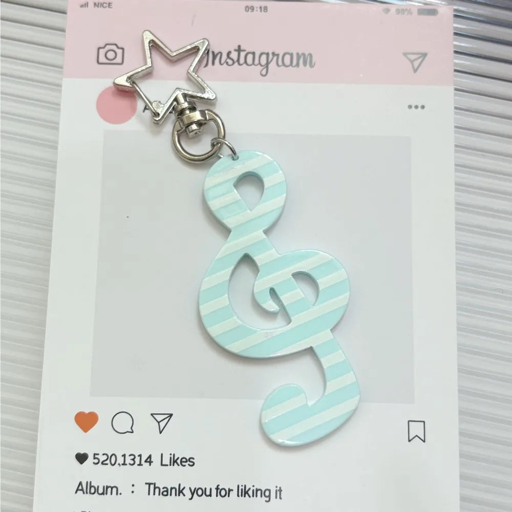 A mint green and white striped fashion cartoon acrylic musical note keychain with a silver star-shaped clasp