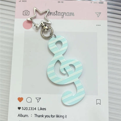A mint green and white striped fashion cartoon acrylic musical note keychain with a silver star-shaped clasp