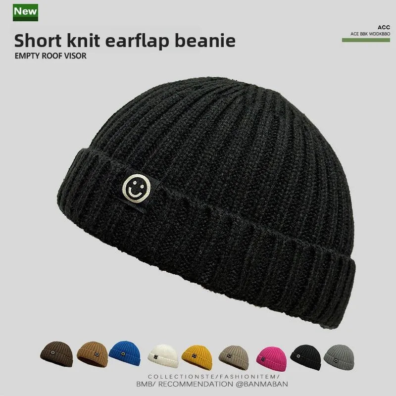 Black short knit hip hop beanie with ribbed texture and smiley face patch for knitted hat men and skullcap women winter use