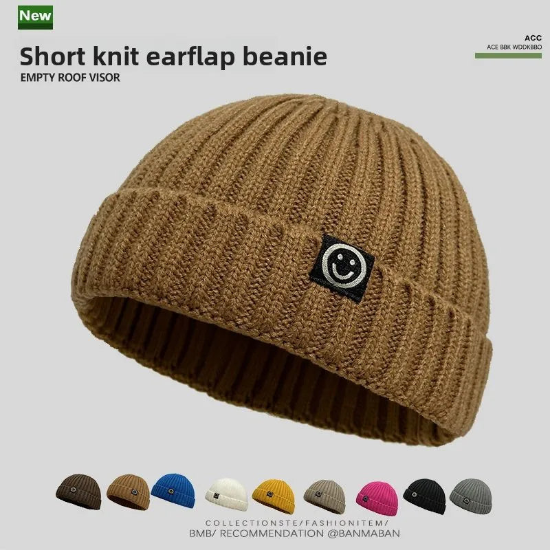 Tan short knit hip hop beanie with ribbed texture and black smiley face patch for men skullcap women winter warm brimless wear