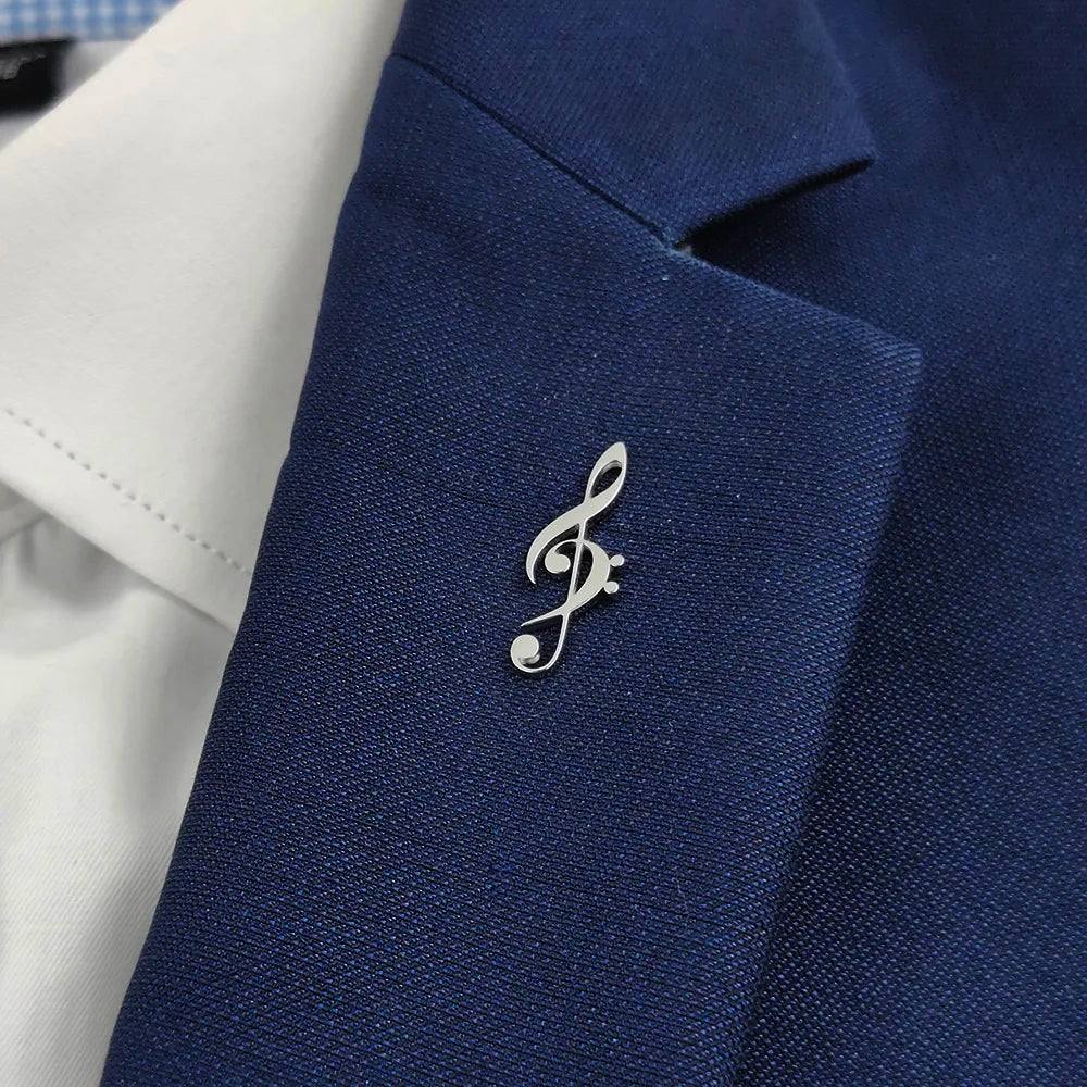 A sleek silver stainless steel music symbol brooch on a navy blue suit jacket, perfect music lover accessories