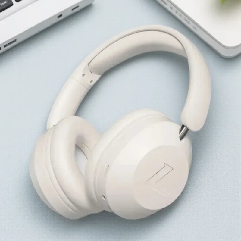 Cream-colored foldable wireless bluetooth over-ear headphones with soft padded earcups and high power stereo sound for sports