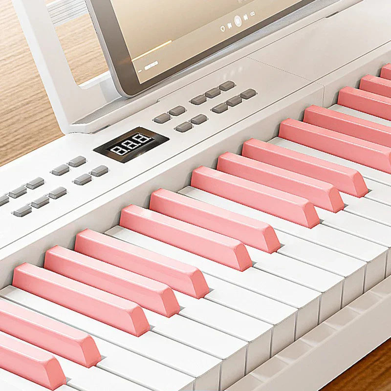 A sleek white folding piano with soft pink and white keys featuring digital display for electronic piano portable use
