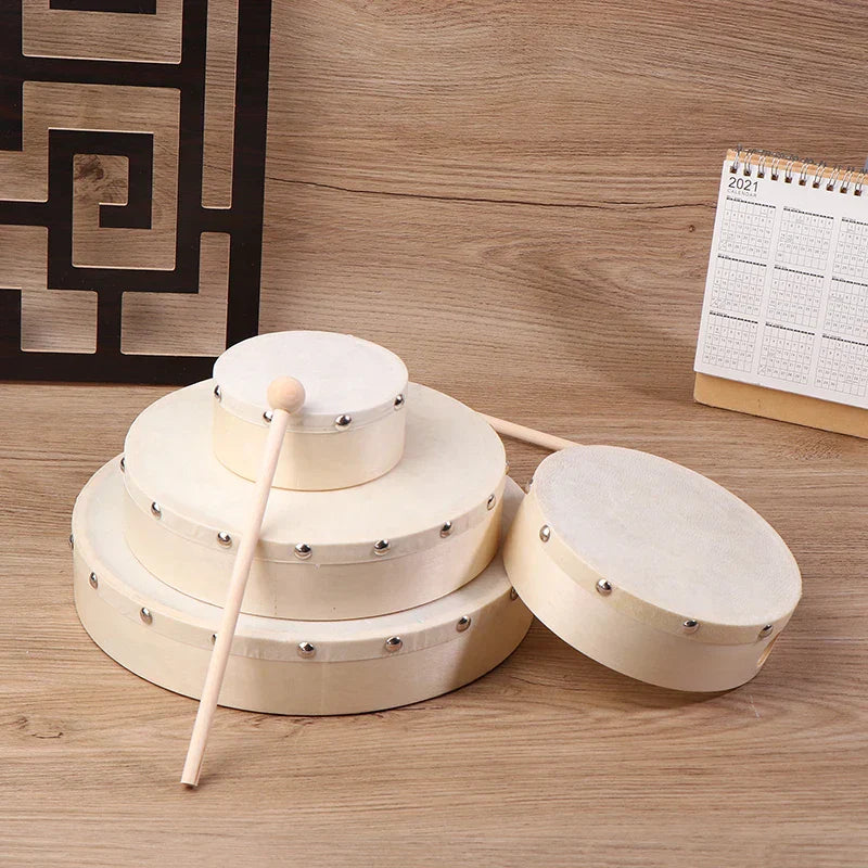 Set of three cream-colored wooden frame drums with metal tuning lugs and drum stick set for kids educational toy