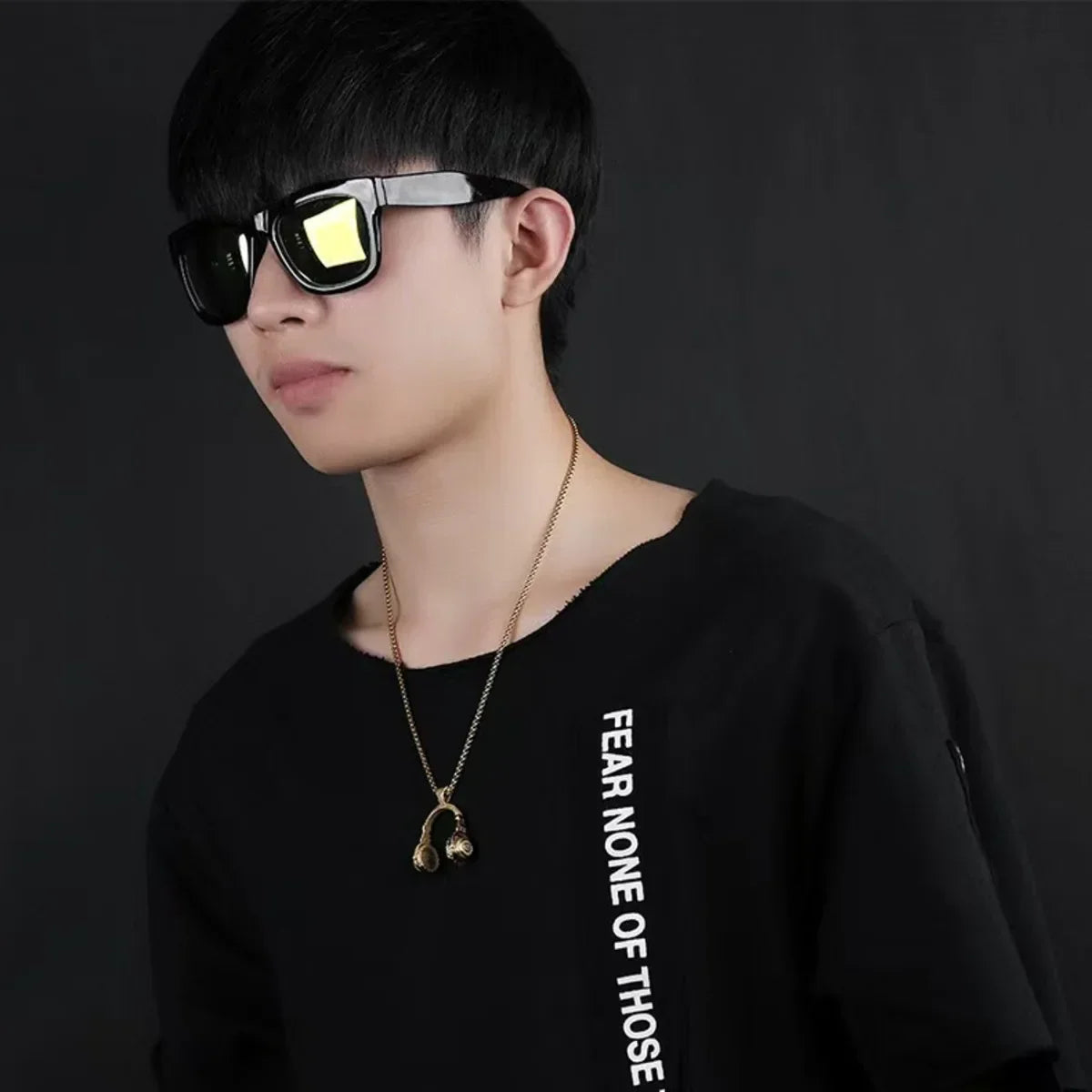 Black-framed sunglasses with reflective yellow lenses paired with fan dj music hip hop jewelry pendant necklace