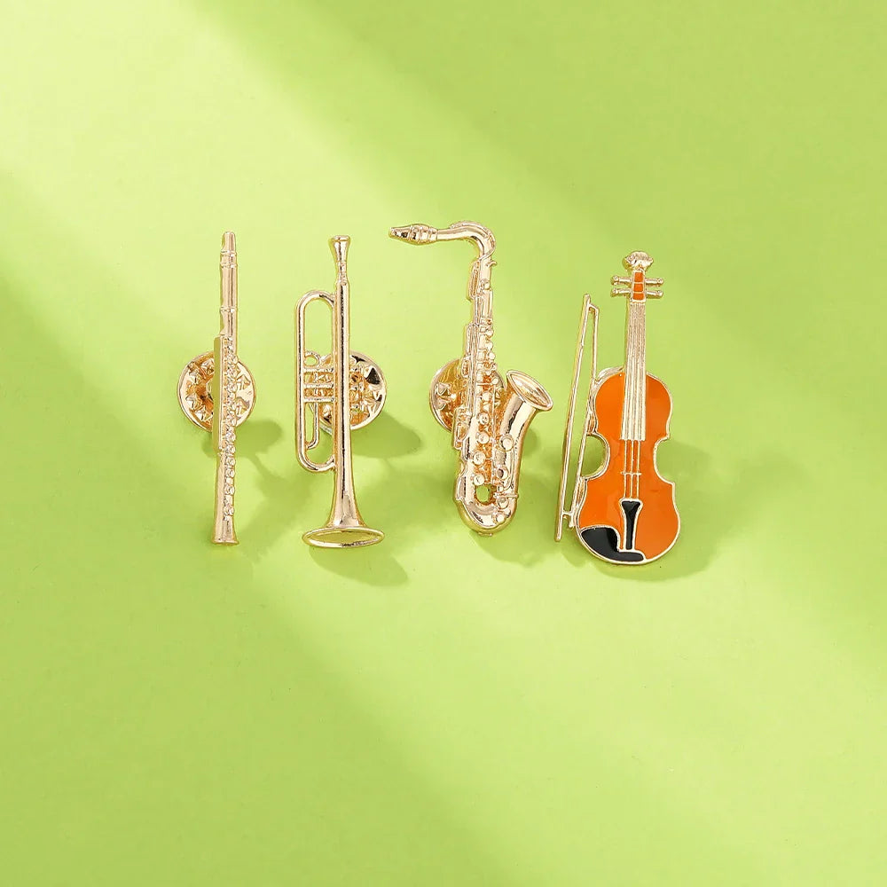 Gold-colored violin-shaped enamel pin with orange body and black accents from funny musical instruments enamel brooches collection