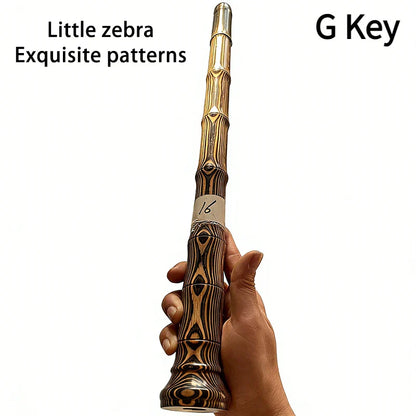 A hand holds a g key of a key wooden xiao with black and gold zebra bamboo patterns for xiao handmade diy chinese vertical bamboo flute