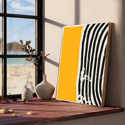A modern graphic abstract canvas featuring bold black and white stripes and a yellow panel in a light wood frame
