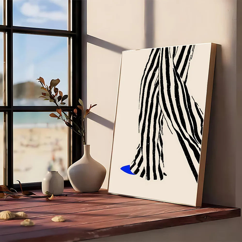 Modern graphic abstract black and white striped canvas art with bold blue accent framed in light wood for wall decor
