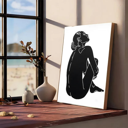 Modern graphic black silhouette art print of a seated woman framed in light wood kraft club vintage wall art poster