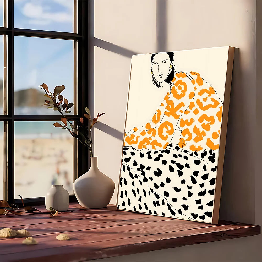 A modern graphic canvas print with a stylized woman in orange and black leopard print framed in wood for wall art