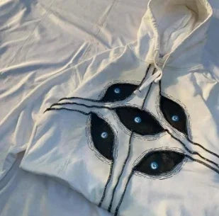 White hoodie with bold black gothic punk eye graphic featuring blue centers in pattern patchwork hoodies women y2k style