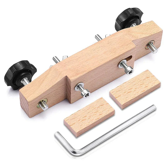 Light-colored wooden guitar bridge clamp with black knobs, metal screws, hex key, and two wood blocks for acoustic guitar accessory luthier tools