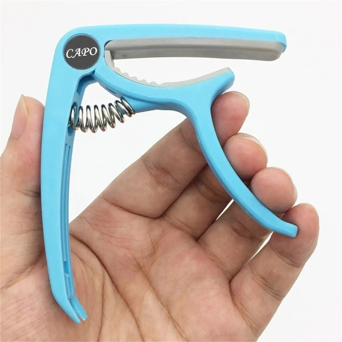 Light blue plastic guitar capo with silver spring and black capo logo for acoustic classic guitar and musical instrument ukulele