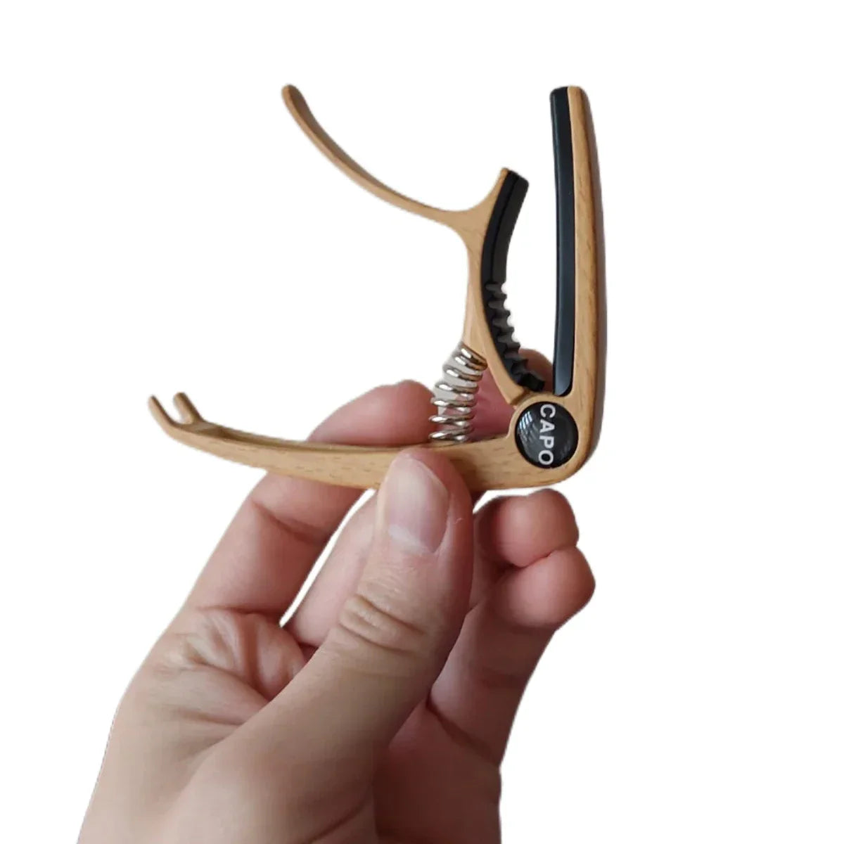 A light wood-finished guitar capo metal with black rubber grip and zinc alloy construction for acoustic and electric guitars