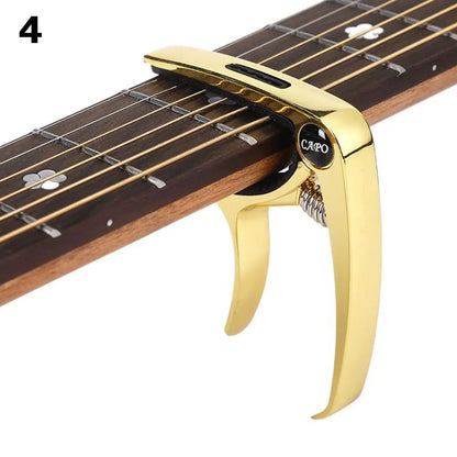 Gold-colored guitar capo metal made of alloy with polished finish and capo brand for acoustic electric musical instruments