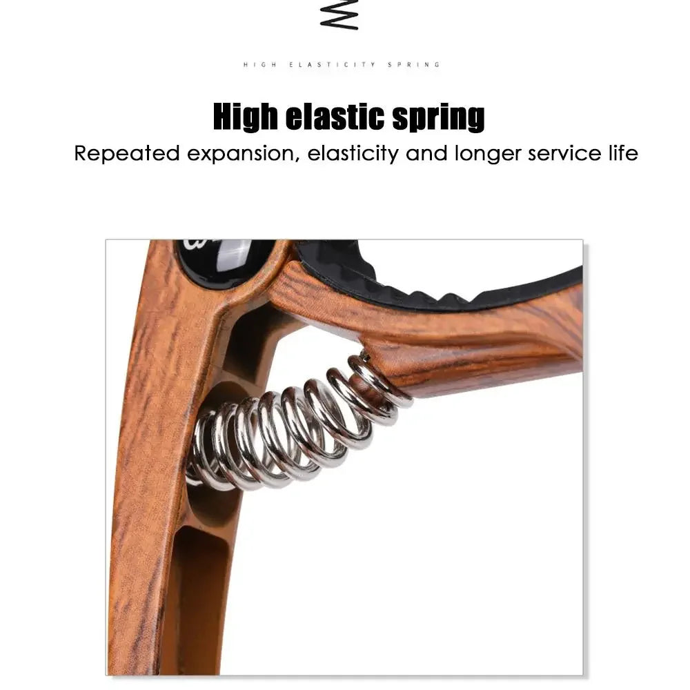 Wooden-handled hand gripper with shiny metallic spring alongside guitar capo metal alloy guitar tuner for acoustic electric musical use