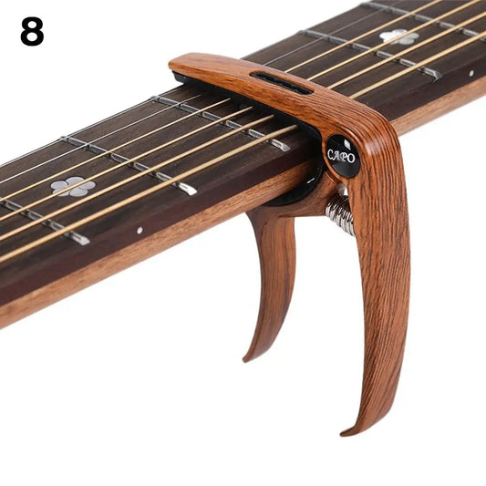 A wooden guitar capo with a polished finish and adjustable spring for acoustic electric musical instruments