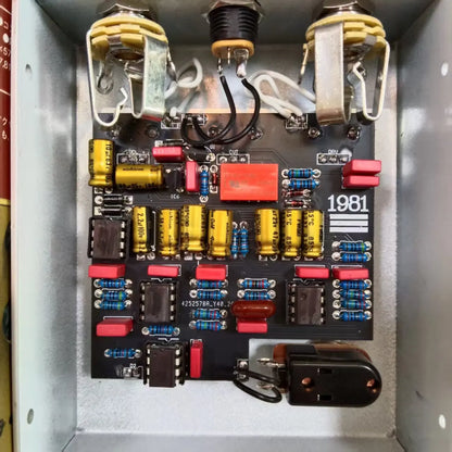 Black circuit board with yellow capacitors red resistors and silver toggle switches in mr xiao guitar effector 1981 with unique mid-frequency overdrive effect