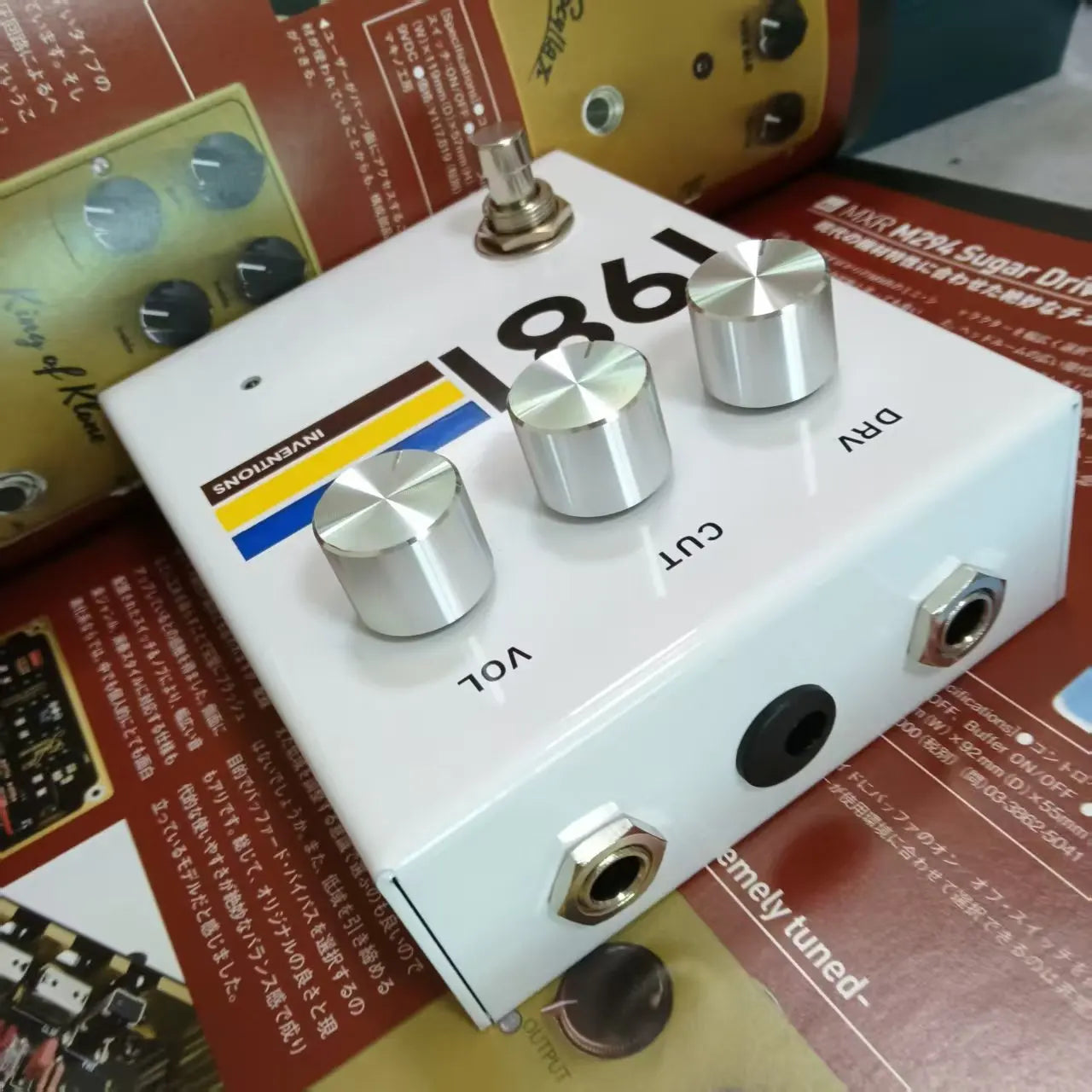 White rectangular guitar effector 1981 stompbox overdrive pedal with unique mid-frequency colorful stripe design by inventions