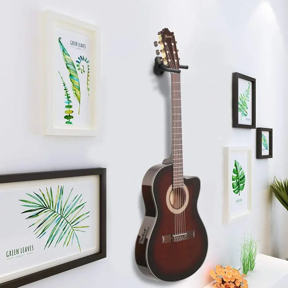 A dark brown acoustic guitar with glossy finish mounted on black metal guitar wall mount hanger hook acoustic electric bass guitar