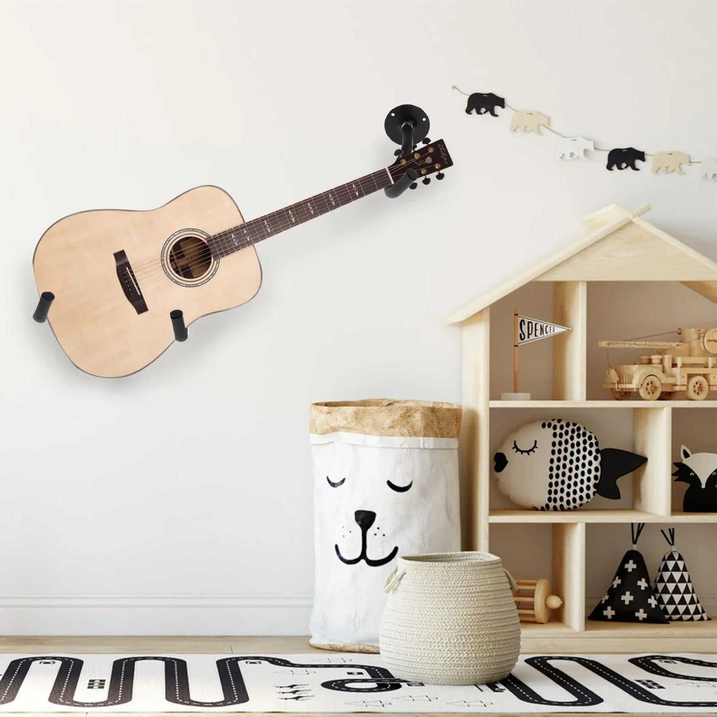 Light-colored acoustic guitar with natural wood finish mounted on a guitar wall mount for music shop exhibition