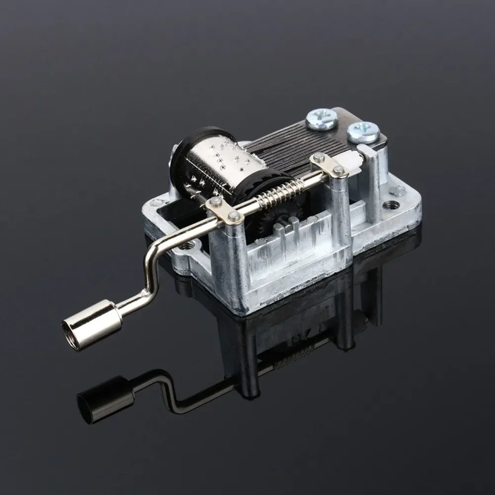 Silver metallic hand crank music box with visible diy craft mechanism and box musical movement gears and crank handle