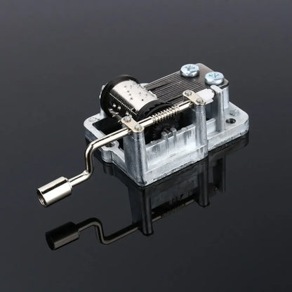 Silver metallic hand crank music box with visible diy craft mechanism and box musical movement gears and crank handle