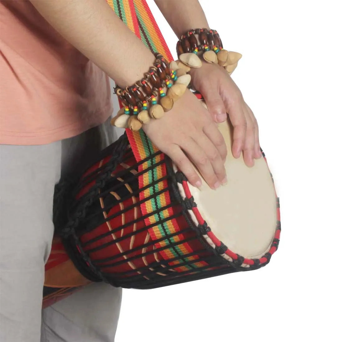 Handwoven djembe african drum with red green yellow striped pattern paired with handmade nuts shell conga percussion accessories