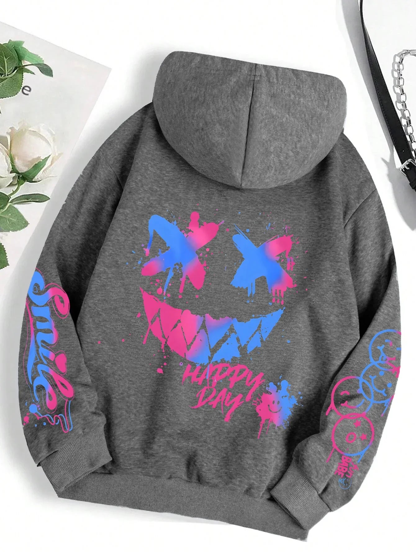 Gray hoodie street hip featuring happy day graffiti print with vibrant blue pink smiley face and sleeve graphics