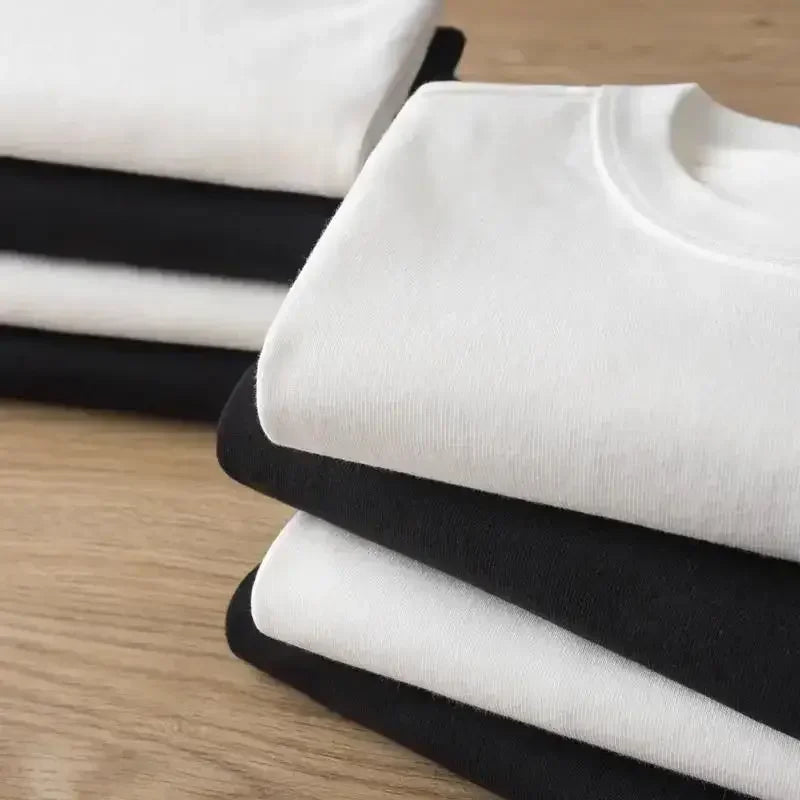 Stack of neatly folded white and black cotton harajuku hip-hop xrlafamilia album tour t-shirts for rapper kheis fans