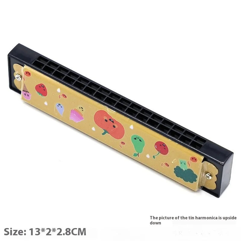 A yellow tin harmonica toy with black plastic casing featuring cartoon fruits for educational musical instrument use
